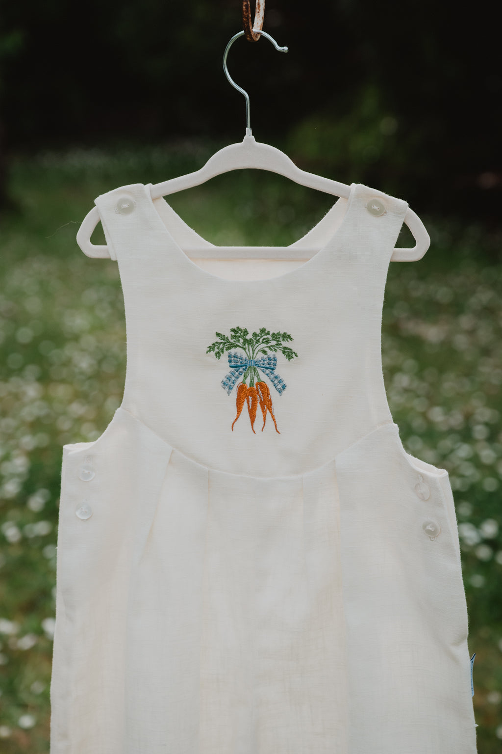 Salopette unisex in lino lavato bianco panna, dettaglio ricamo carote sul davanti