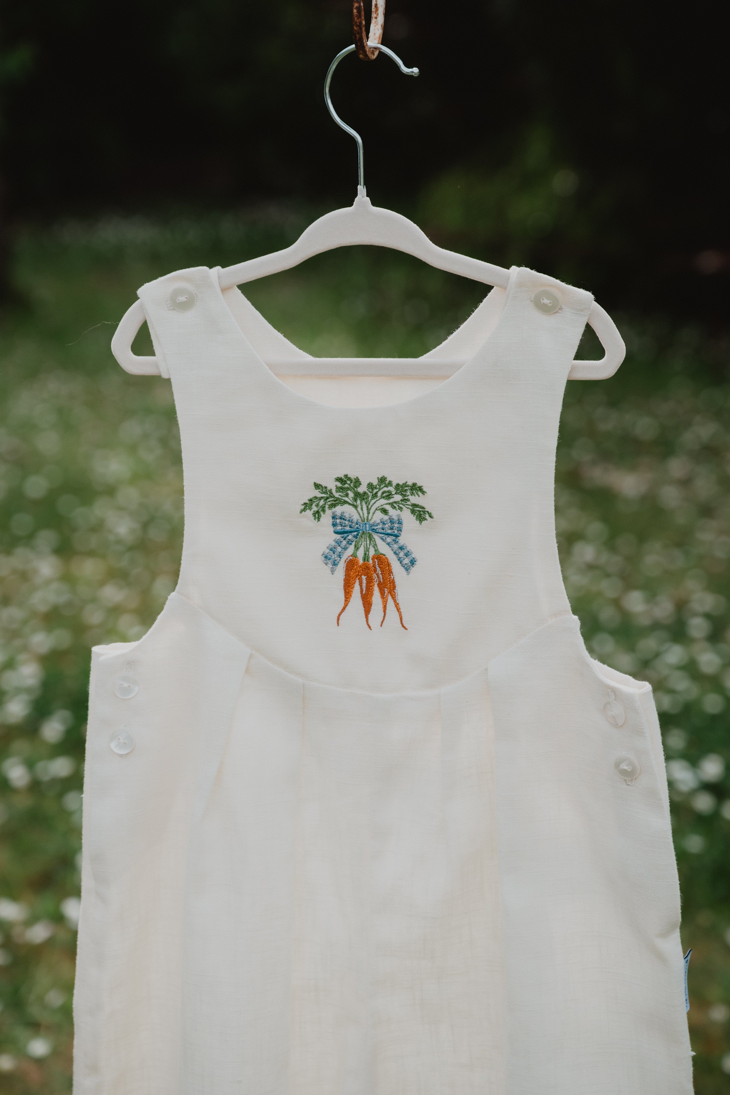 Salopette unisex in lino lavato bianco panna, dettaglio ricamo carote sul davanti