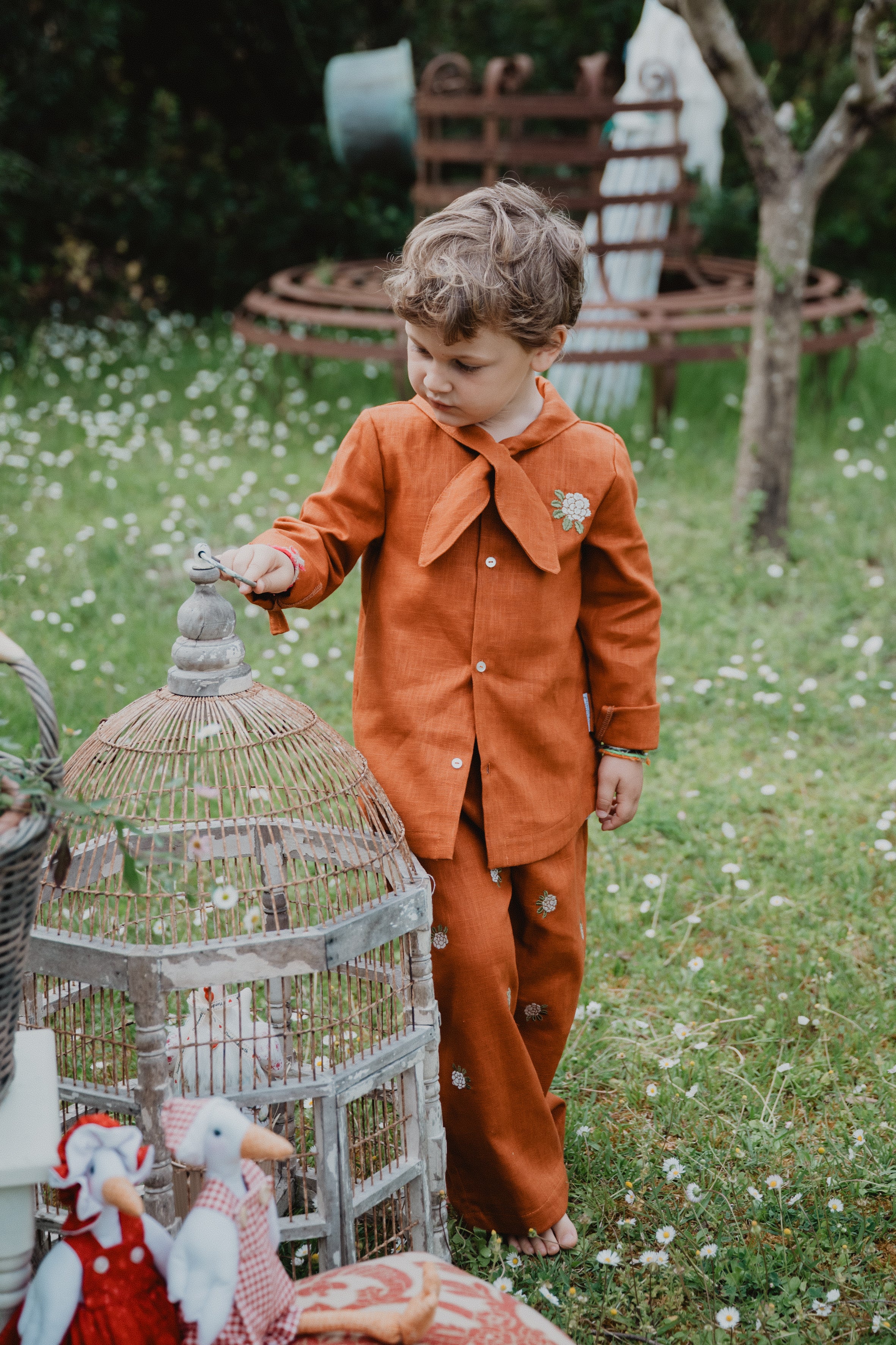 Camicia bambino arancione con collo a bandana annodato e ricamo floreale