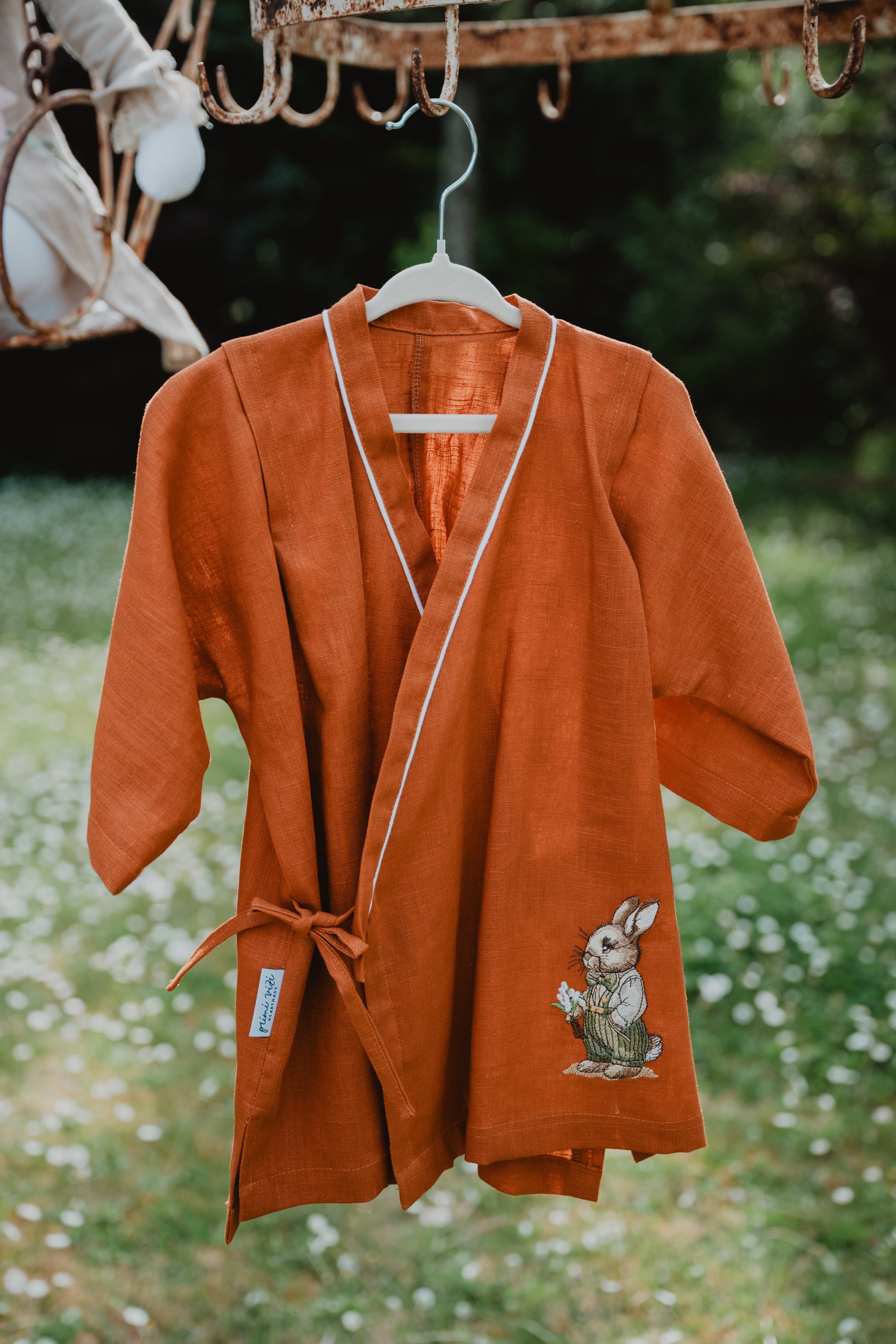Camicia kimono in lino lavato arancione appesa, bordo arancione, ricamo coniglio