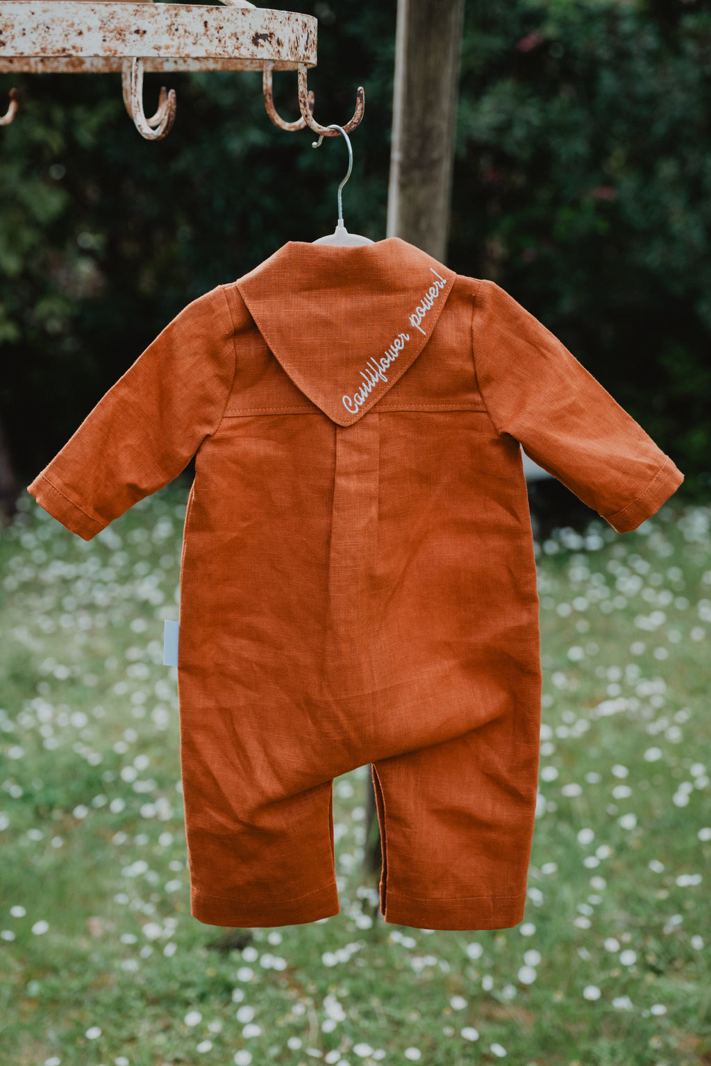 Tutina neonato in lino color cognac con ricamo sul retro del colletto e bottoni