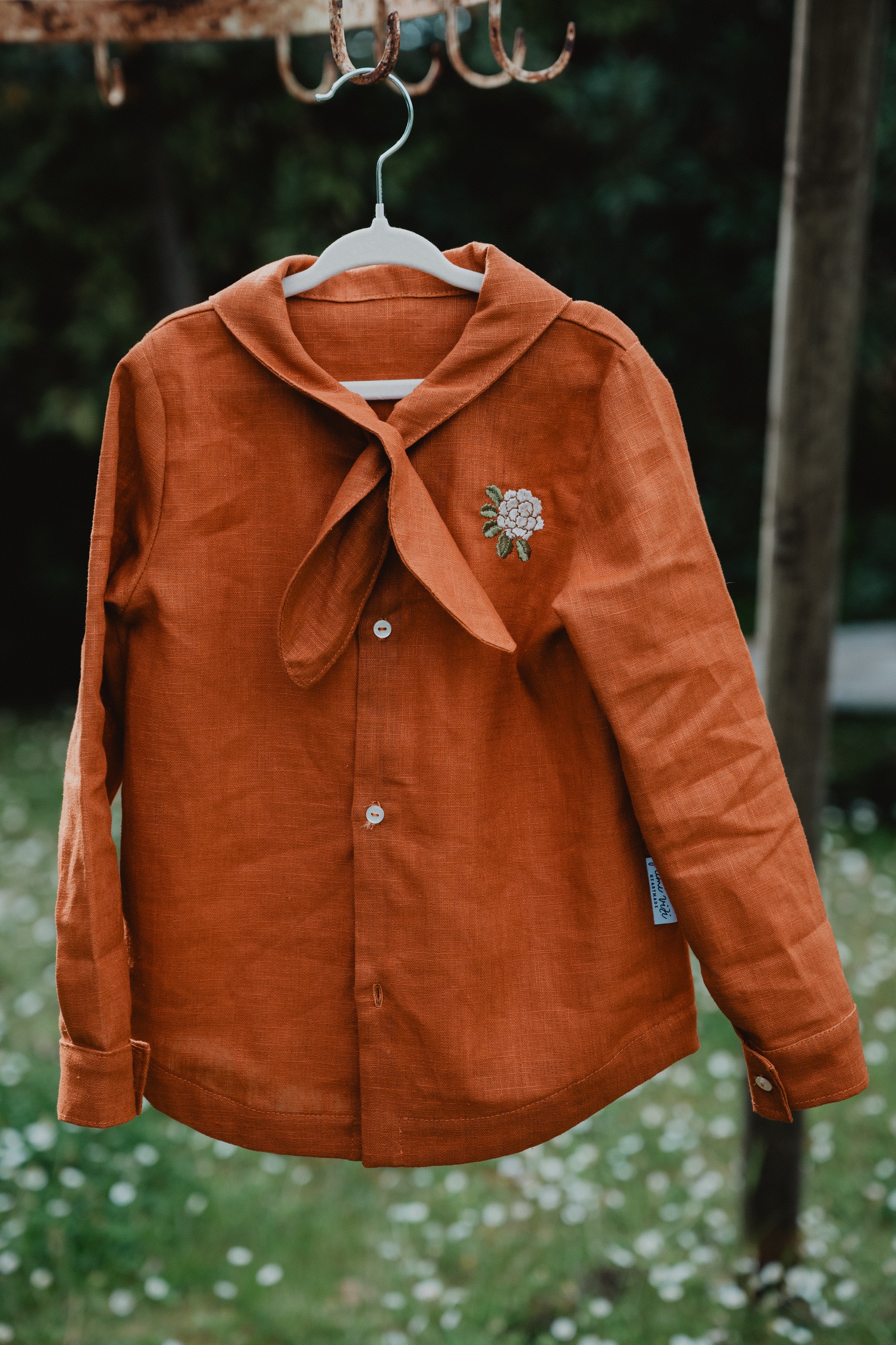 Camicia bambino arancione con collo a bandana annodato e ricamo floreale