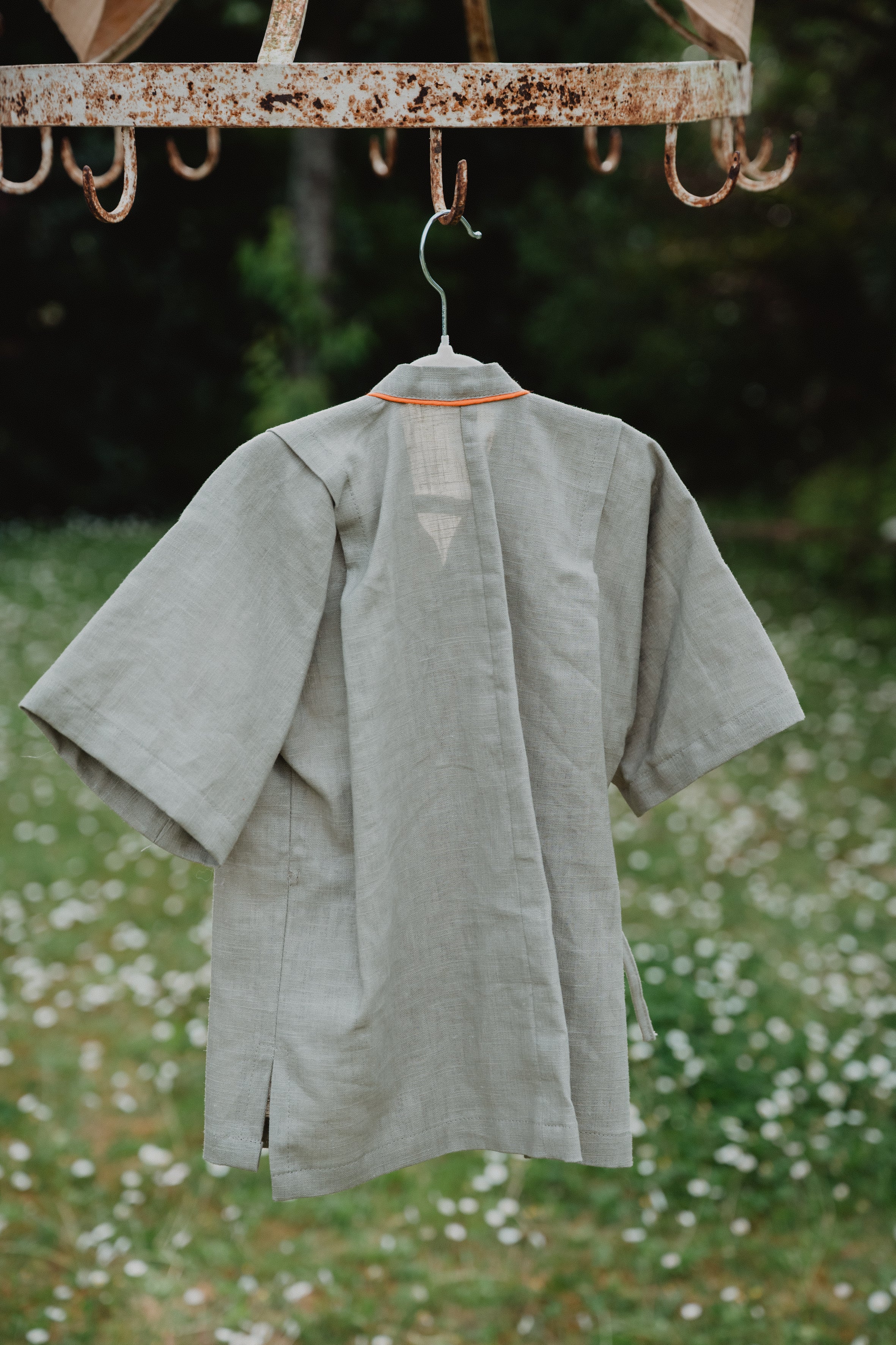 Camicia kimono in lino lavato verde oliva appesa, apertura posteriore e laccetti