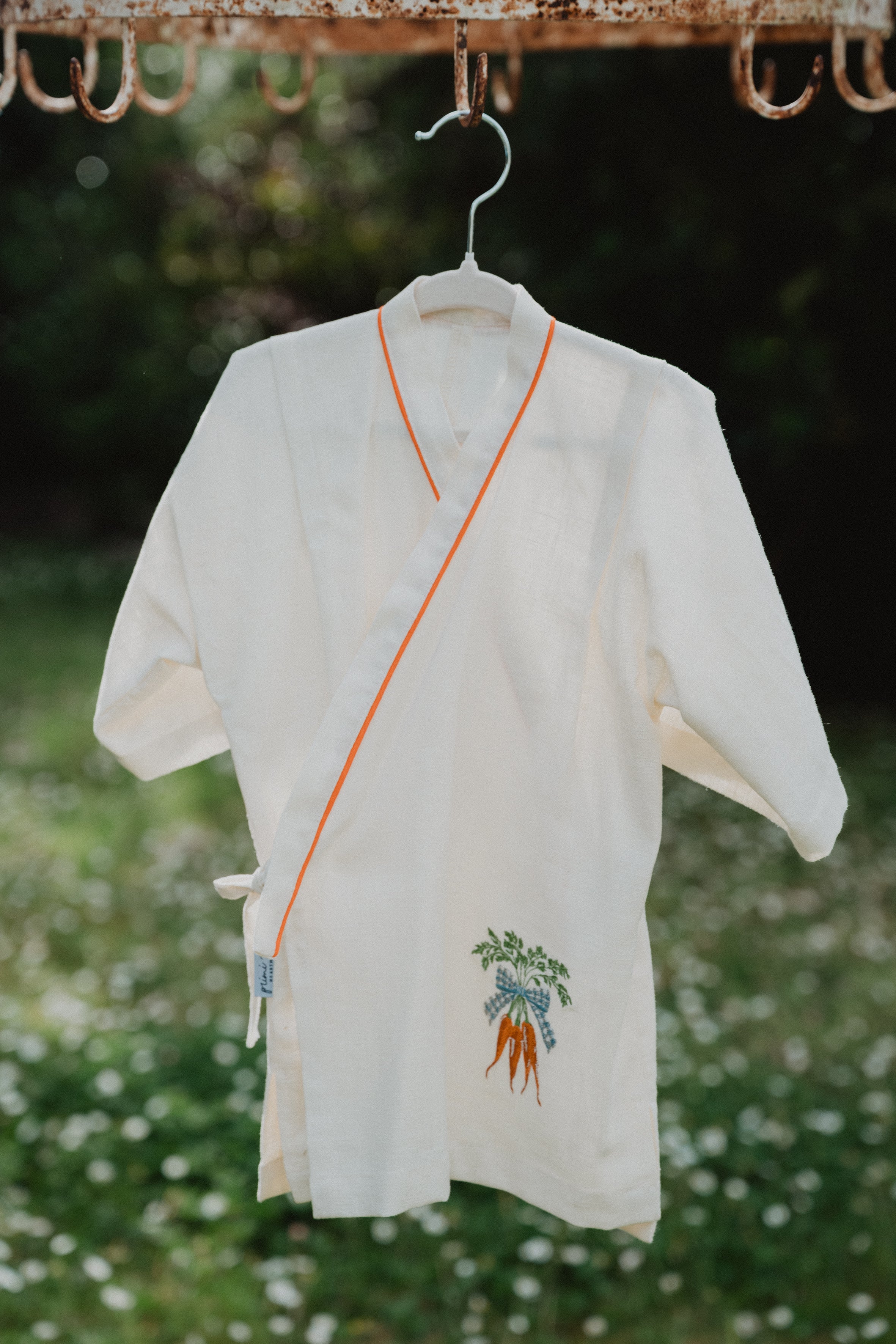 Camicia kimono in lino lavato panna appesa, bordo arancione e ricamo carote