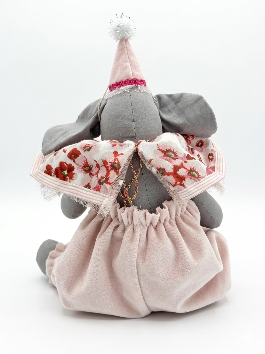 Elefante di peluche grigio con cappellino rosa, abito rosa e motivo a fiori