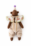 Orsetto di peluche marrone con cappello viola a pon pon e vestitino fantasia
