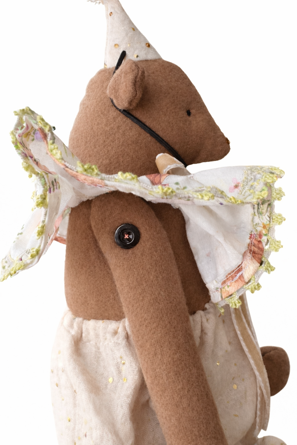 Orsetto di peluche marrone con vestito bianco e bottone nero sulla gamba