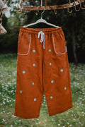 Pantaloni baggy in lino lavato cognac, coulisse bianca e ricami a fiori