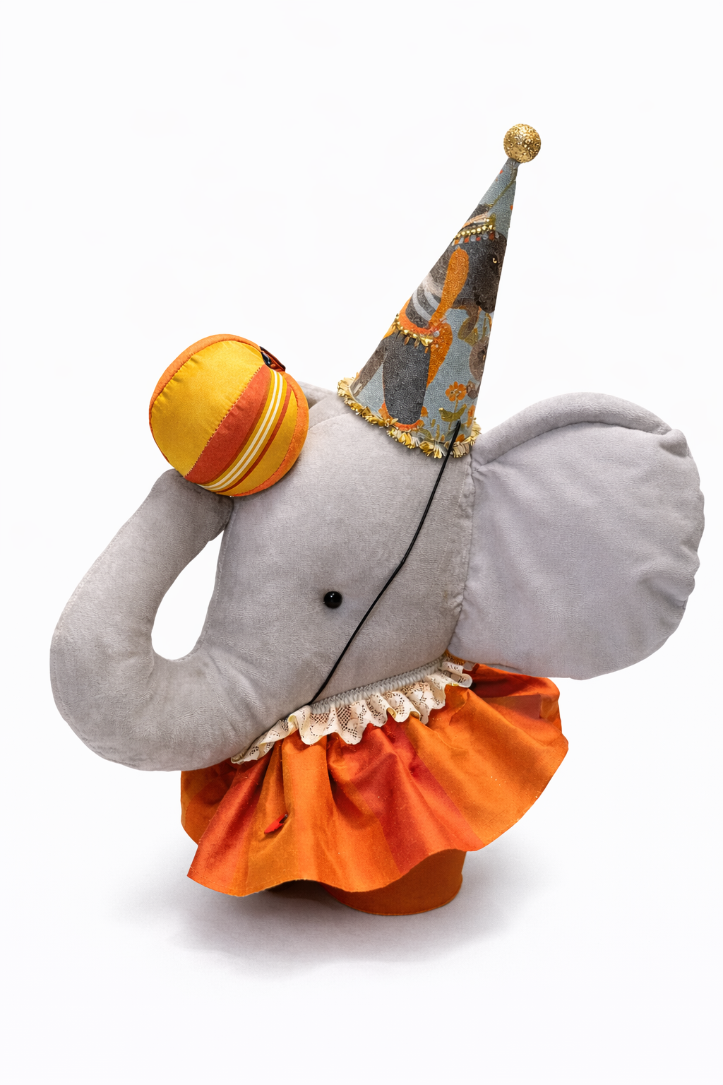 Elefante di peluche grigio con tromba fantasia e gonna arancione a balze